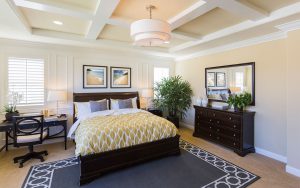 A bedroom with a bed, dresser and mirror.